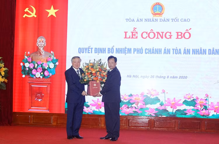Đồng chí Nguyễn Hòa Bình trao quyết định và chúc mừng đồng chí Nguyễn Văn Tiến.
