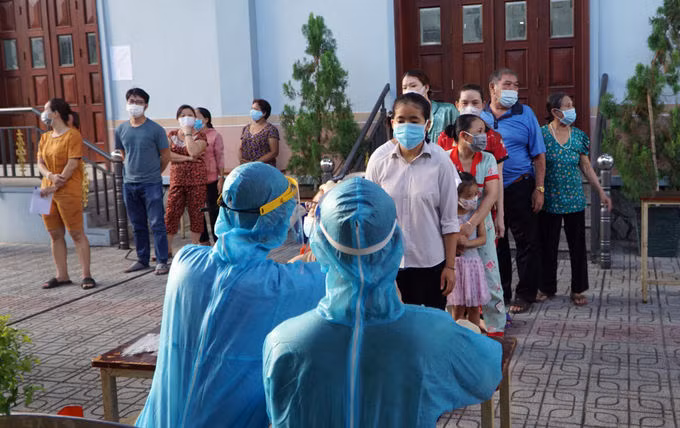 Người dân phường 15 xếp hàng theo nhóm hộ gia đình, chờ lấy mẫu xét nghiệm nCoV. Ảnh: Thư Anh.