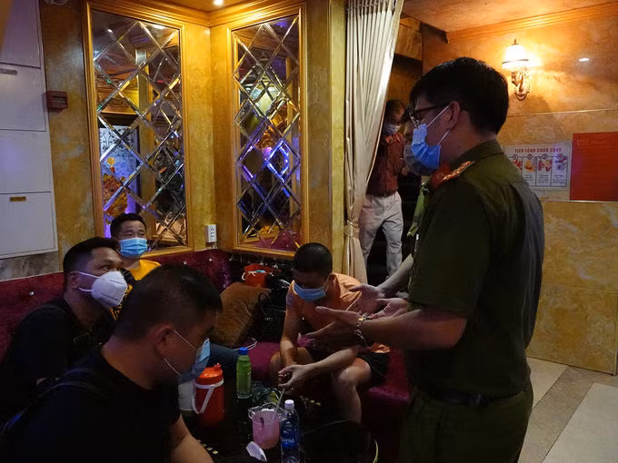 Hát karaoke bất chấp lệnh cấm ở trung tâm TP HCM ảnh 1 Nhiều người nước ngoài ở các phòng karaoke được yêu cầu lấy mẫu xét nghiệm. Ảnh: Đinh Sự.