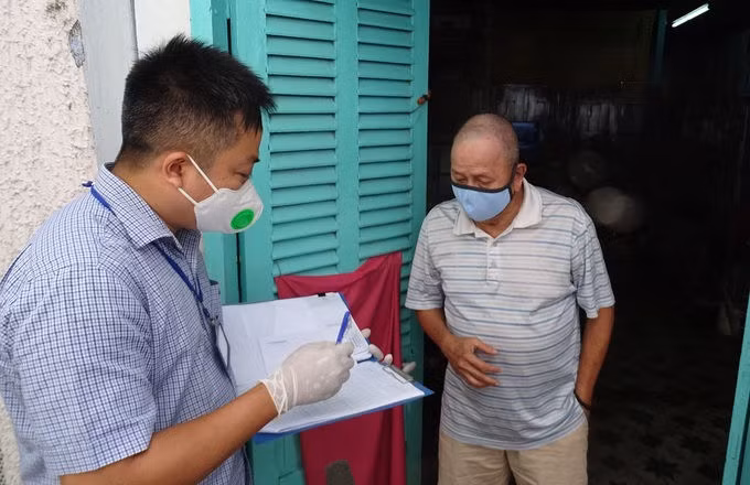 Cán bộ phường Đa Kao đến nhà đối chiếu thông tin để trao tiền hỗ trợ cho người lao động tự do. Ảnh: Hà An.