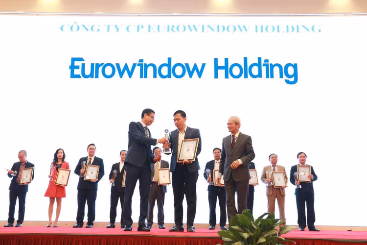 Thứ trưởng Bộ KH&CN Lê Xuân Định và Chủ tịch Hội Vật liệu xây dựng Việt Nam Tống Văn Nga trao Kỷ niệm chương và Chứng nhận “Điển hình tiên tiến trong sản xuất và sử dụng vật liệu xây không nung” cho đại diện Eurowindow Holding.