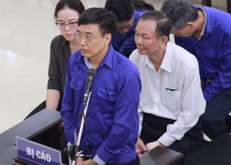 Ông Hồng&nbsp;bị còng tay khi trả lời HĐXX vào đầu phiên xét xử. Ảnh: Việt Dũng