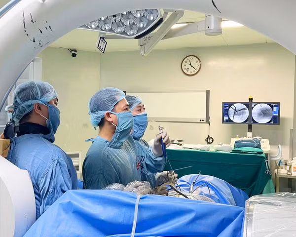 Ekip đang thực hiện phẫu thuật nội soi hai cổng giải chèn ép ống sống cho người bệnh - Ảnh BVCC