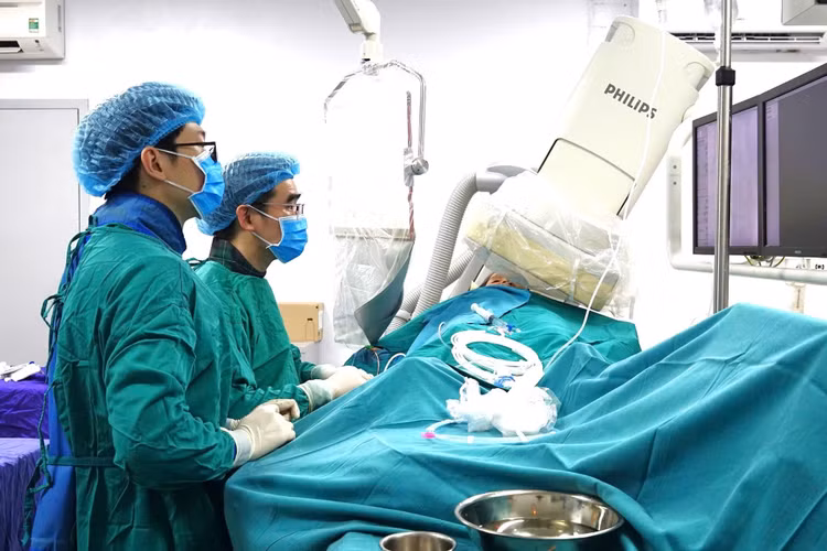 Êkip can thiệp tim mạch do Thạc sĩ, bác sĩ Đinh Danh Trình, Phó khoa Tim mạch, Bệnh viện Bãi Cháy đang tiến hành đặt 02 stent phủ thuốc nhánh LAD 1-3 để tái thông dòng máu nuôi tim đang bị tắc nghẽn cho bệnh nhân. - Ảnh BVCC