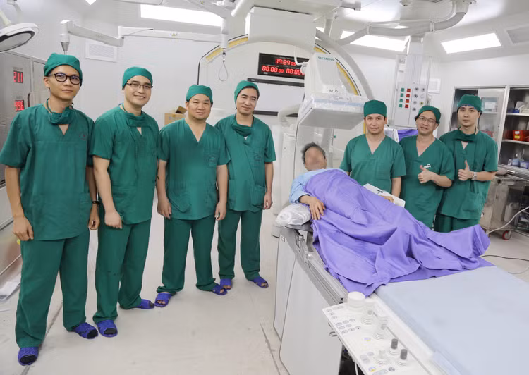 Bệnh nhân tỉnh táo chụp ảnh lưu niệm cùng kíp bác sĩ ngay sau can thiệp.